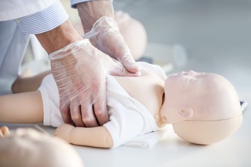 Doctor practising infant chest compressions