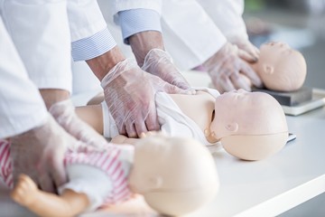 Doctors practising infant chest compressions