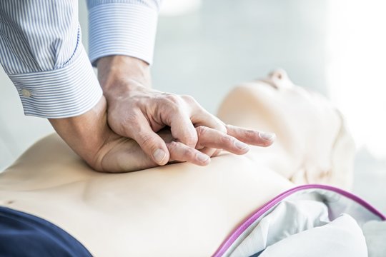 First-aider practising chest compressions