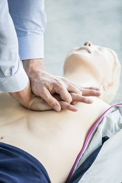 First-aider practising chest compressions