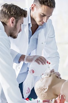 Doctor practising bag-valve-mask ventilation on dummy