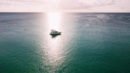Alone yacht in a beam of the sun. Caribbian sea.
