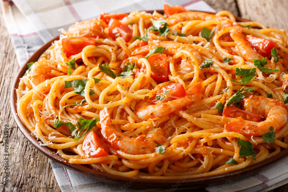 Poster italian pasta spaghetti with prawns, parmesan and herbs in tomato diavolo sauce close-up. horizontal