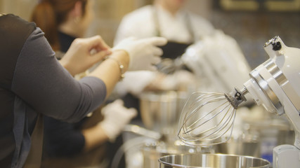 Woman on the kitchen near electric mixer ready for cooking