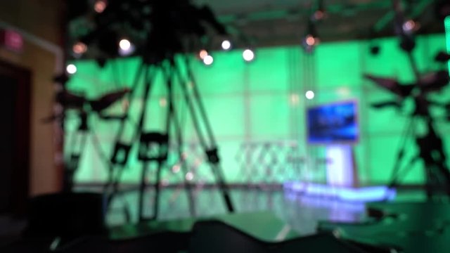 News Studio. Silhouette of a man and a digital video camera in front of a green screen.