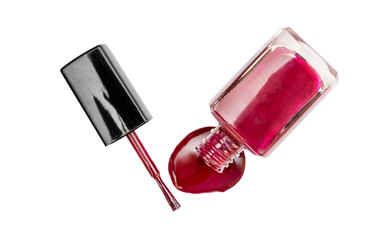 Red nail polish spilled from the bottle with brush on white background. Top view.