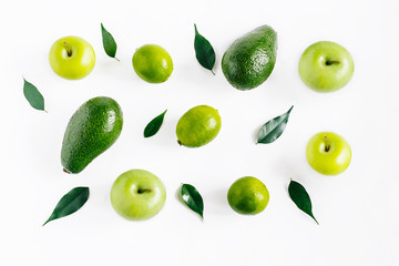 Green  fruits avacado, apples, lime and leaves creative concept top view on the white background.