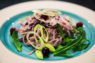 Vegetable salad. Sliced beef and fresh salad with purple onions, topped with balsamic mousse, rocket salad on the background of dark wood. Health food.