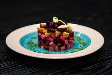 traditional Russian salad with beets, sauerkraut, beans, crackers, onions, cucumbers, potatoes (vinaigrette)