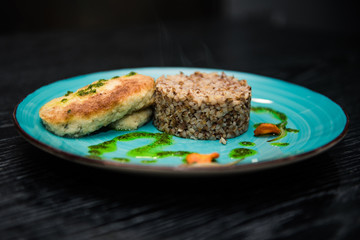 buckwheat porridge with a cutlet on a blue plate. Buckwheat cereal with schnitzel.