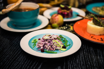 Vegetable salad. Sliced beef and fresh salad with purple onions, topped with balsamic mousse, rucola on the background of other dishes. Health food.