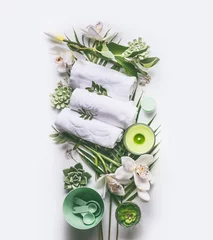 Foto op Canvas Green spa or wellness composing with towels, candle, tropical leaves , orchid flowers, succulents and body and face care tools and accessories on white background, top view © VICUSCHKA