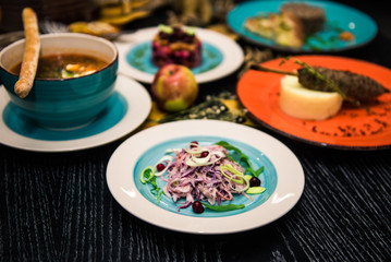 Vegetable salad. Sliced beef and fresh salad with purple onions, topped with balsamic mousse, rucola on the background of other dishes. Health food.