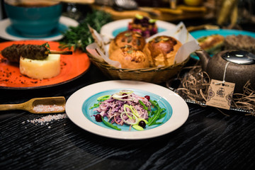 Vegetable salad. Sliced beef and fresh salad with purple onions, topped with balsamic mousse, rucola on the background of other dishes. Health food.