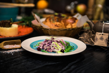 Vegetable salad. Sliced beef and fresh salad with purple onions, topped with balsamic mousse, rucola on the background of other dishes. Health food.