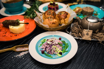 Vegetable salad. Sliced beef and fresh salad with purple onions, topped with balsamic mousse, rucola on the background of other dishes. Health food.