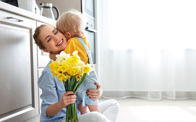 happy mother's day! baby son gives flowersfor  mother on holiday .