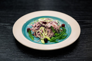 Vegetable salad. Sliced beef and fresh salad with purple onions, topped with balsamic mousse, rocket salad on the background of dark wood. Health food.