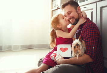 Father's day. Happy family daughter giving dad greeting card .