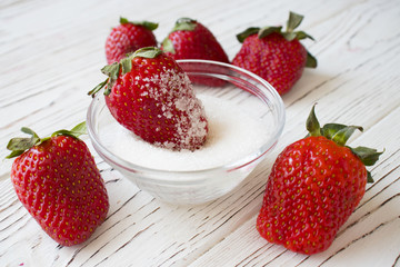 fresh strawberry and sugar on wooden background