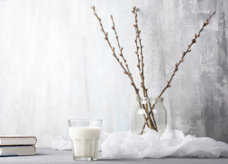 A glass of milk, willow branches and books