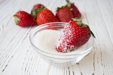 fresh strawberry and sugar on wooden background