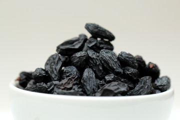 black raisins on white background