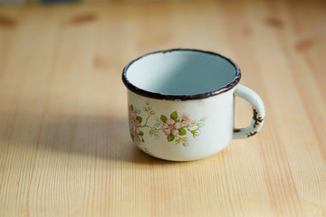 Old mug stands on a wooden table