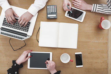 Young business team working on office desk with electronic devices