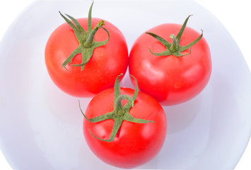 Closeup of tomatoes on white plate isolated