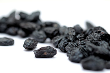 black raisins on white background