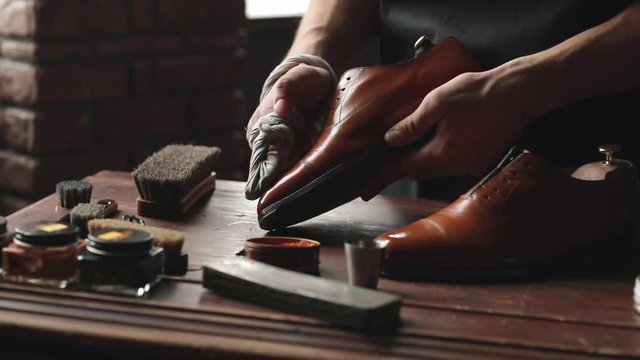 Shoe shop. Shoes master polishes boots