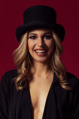 Beautiful woman portrait making funny face while wearing top hat