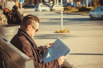 Fototapeta na wymiar Man reading newspaper in the city.