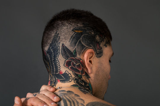 Handsome man back closeup portrait with tattoos on his head and neck