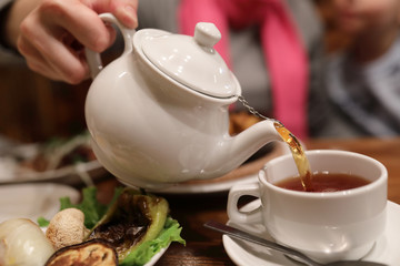 Person filling cup of tea