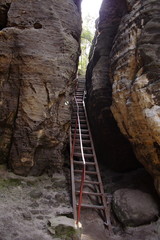 Naklejka premium Narrow iron staircase by stone.
