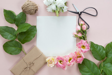 Flat lay of vintage gift box of Kraft eco paper with flower frame wreath on pink background, top view with copy space