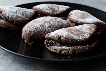 Jelly Filled Chocolate Cookies with Powdered Sugar and Cherry Jam.