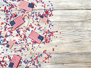 American independence Day, celebration, patriotism and holidays concept - flags and stars on the 4th of July party on top on wooden background