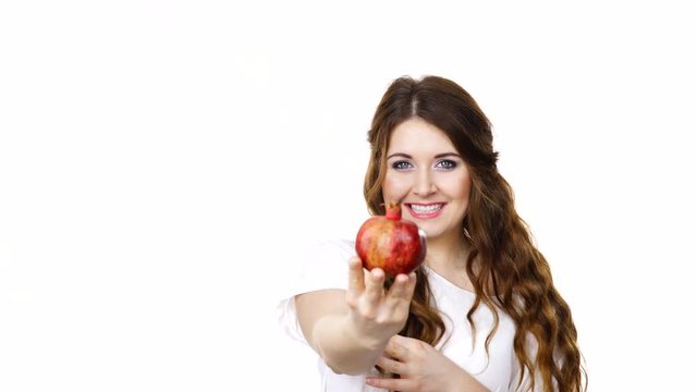 Woman brunette long hair girl offering pomegranate fruit, isolated on white. Healthy eating, cancer prevention, immune support.