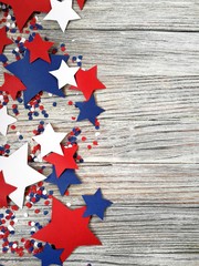 American independence Day, celebration, patriotism and holidays concept - flags and stars on the 4th of July party on top on wooden background