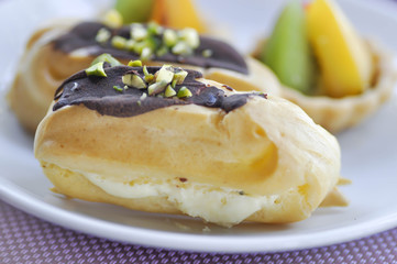 choux pastry with chocolate and pistachio topping or eclair