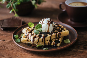 Belgium waffles with chocolate sauce and ice cream .