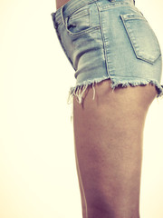 Slim girl wearing denim shorts side view