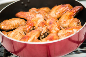 Closeup of baked chicken wings in baking pan. Selective focus