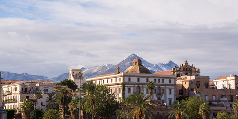 Seafront buildings in Palermo with snowy mountains in the background