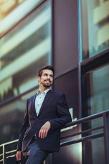 Naklejka premium Portrait of a young happy businessman outside the office building