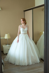 beautiful young bride in white wedding dress in the room