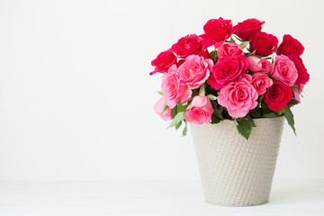 beautiful red rose flowers bouquet in vase over white © Olga Miltsova